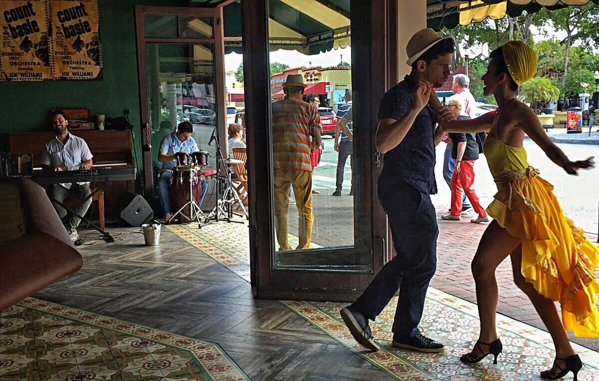 Performers Rene Rodriguez, center, Lidia Clanos, right, salsa dance for passers-by inside the historic establishment Ball &amp; Chain that helped open Calle Ocho to new food options on Wednesday, January 11, 2016.