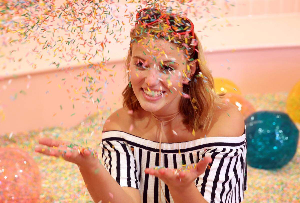 Carlen Dickerson with University of Miami TV,  plays in the 'Sprinkle Pool," a pool filled with 100 million non-edible, colorful sprinkles at The Museum of Ice Cream on Collins Ave. in Miami Beach, Thursday, Dec. 7, 2017. The museum offers guests the chance to taste, smell, swing and even swim in all things ice cream. (Emily Michot/Miami Herald)