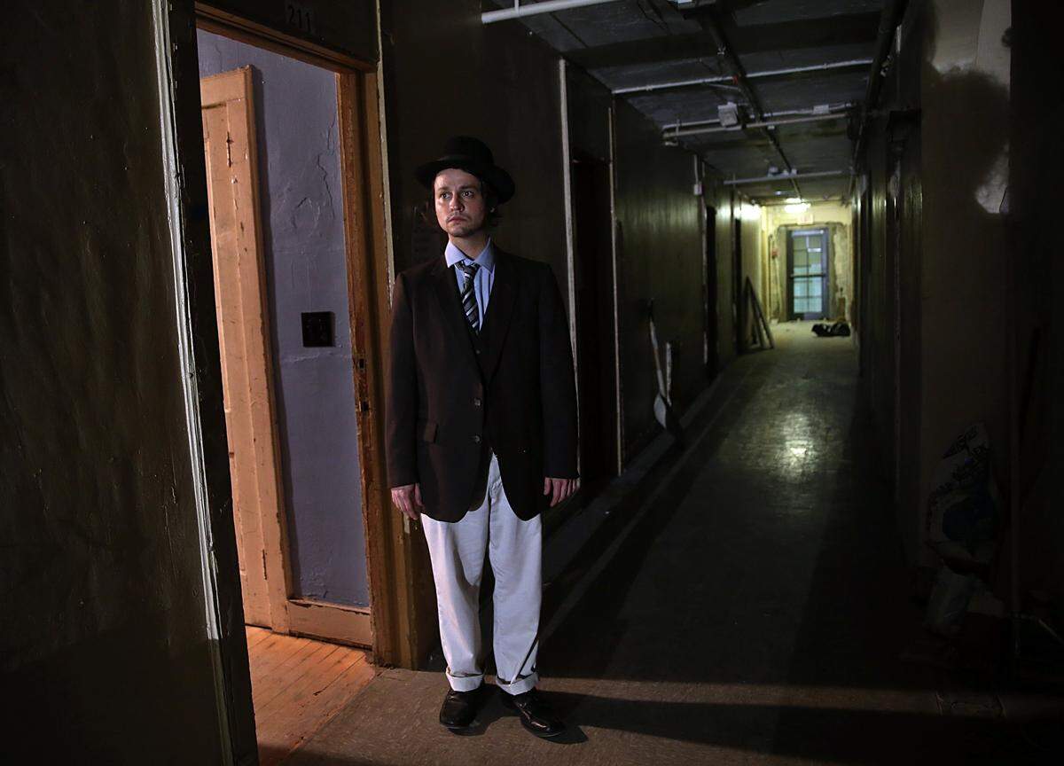 Adam Craine as Iosef stands inside his room on the second floor during a rehearsal of one of the short plays.