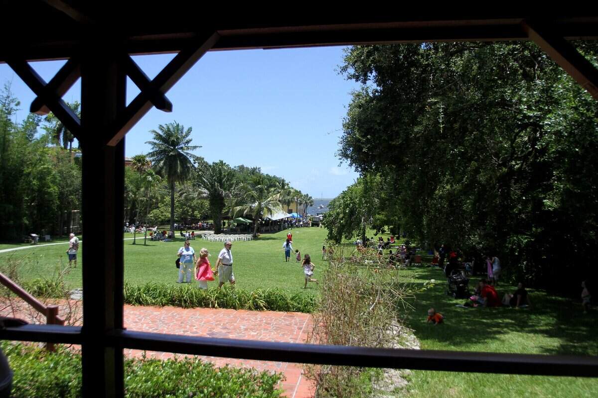 Families enjoy a picnic and kite flying on the lawn during a celebration at the Barnacle Historic State Park in Coconut Grove.
