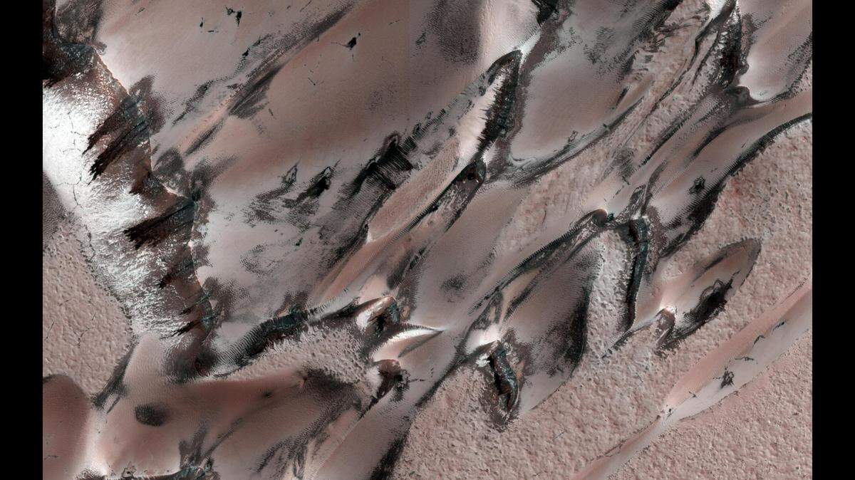 Esta imagen muestra dunas de arena en Marte cubiertas de escarcha justo después del solsticio de invierno. La escarcha es una mezcla de hielo de dióxido de carbono y hielo de agua, según la NASA.