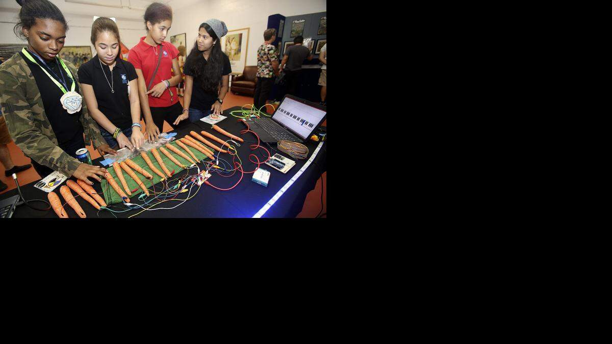 
Critical thinking class students from Frank C. Martin International K-8 Center World School in Richmond Heights make music with a "carrot piano" designed and built by Victor Vincent of Miami, at the Miami Mini Maker Faire in Wynwood on Saturday, Nov. 8, 2014. At the keyboard are Thajia Hepburn, left, Melody Carter, Madison Ryan, all 13, and Maya Singh, 12. The students were on a field trip to the event, described as a festival of creativity, innovation and resourcefulness in celebration of the Maker Movement, the Faire returned to Wynwood for the second year. It's a celebration of the growing creative maker movement in South Florida.
