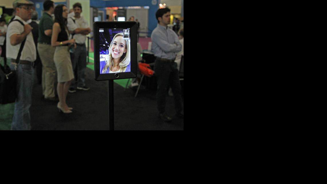 
Miami Children's Health System's Katherine Quinn remotely greets visitors at a busy exhibit at eMerge Americas TechWeek at the Miami Beach Convention Center in May. eMerge Americas is returning in May.
