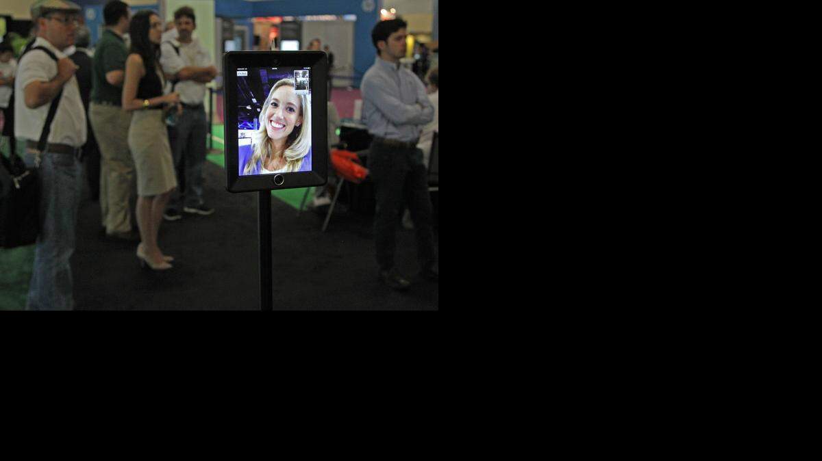 
Miami Children's Health System's Katherine Quinn remotely greets visitors at a busy exhibit at eMerge Americas TechWeek at the Miami Beach Convention Center in May. eMerge Americas is returning in May.
