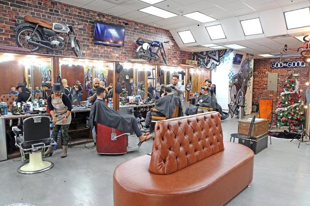 The Spot Barbershop in Coral Gables. Every location in the five-location chain is designed differently, some with motorcycles or car parts on the walls, industrial lights, and all with vintage leather chairs and a sign that says ‘God is Good’ — their mantra.