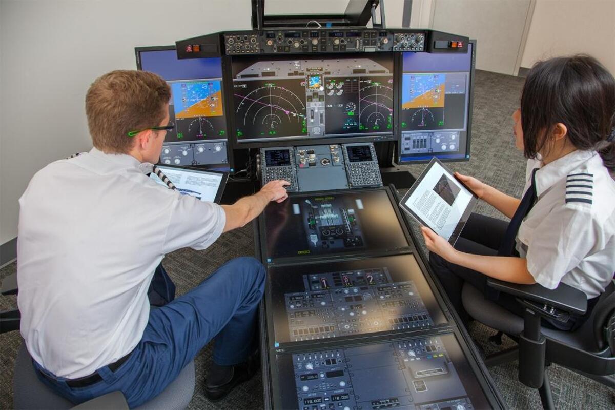 Models pose as students at the 737MAX 3D flight deck simulator in Miami in a Boeing handout photo.