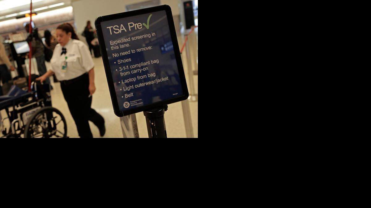 
Travelers make their way through Concourse D during the Holiday week on November 25, 2013 at Miami International Airport with help of TSA PreCheck signs.
