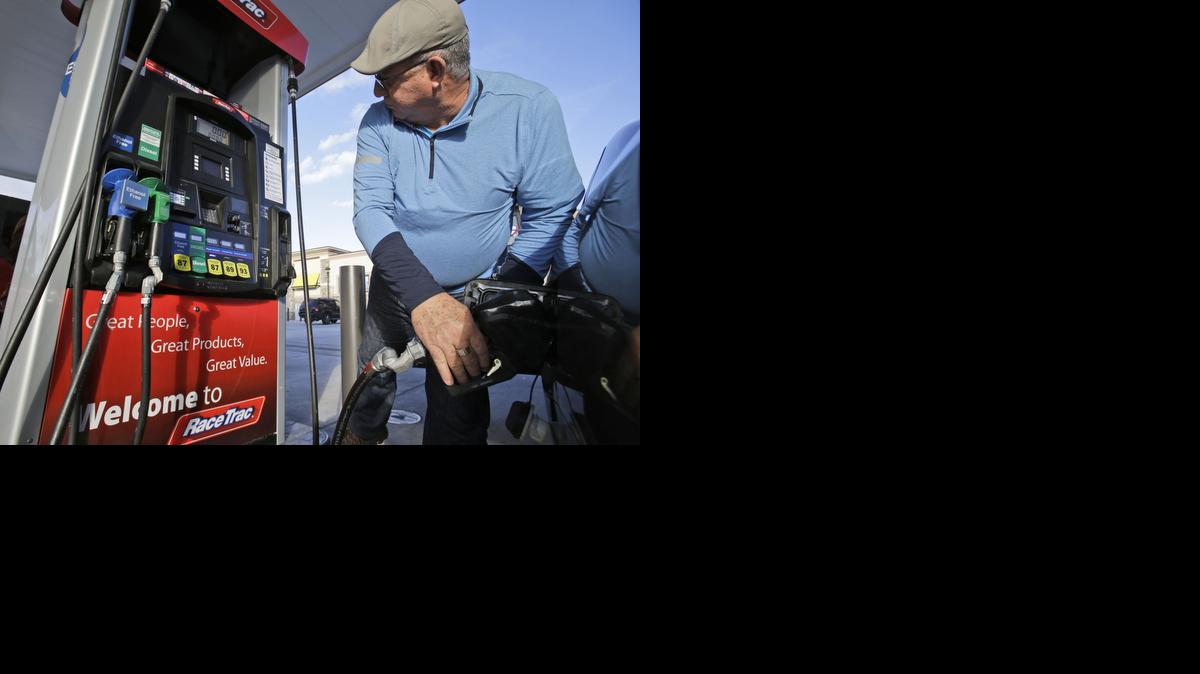 
Eduardo Palacios-Paez of Miami pumps gas at a RaceTrac gasoline station Thursday in Hialeah, Fla. Motorists are now seeing prices under $3 a gallon for the first time in four years. That makes drivers happy, and it also makes gas station owners happy because they are paying less and making more on fuel.
