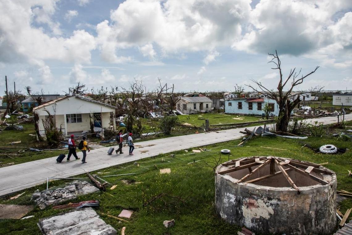 A Red Cross crew accompanies Peter Cuffy and his wife, Jenita Cuffy, as they walk through Codrington, their town on the island of Barbuda, in the aftermath of Hurricane Irma. Their home is among the many damaged by the storm.