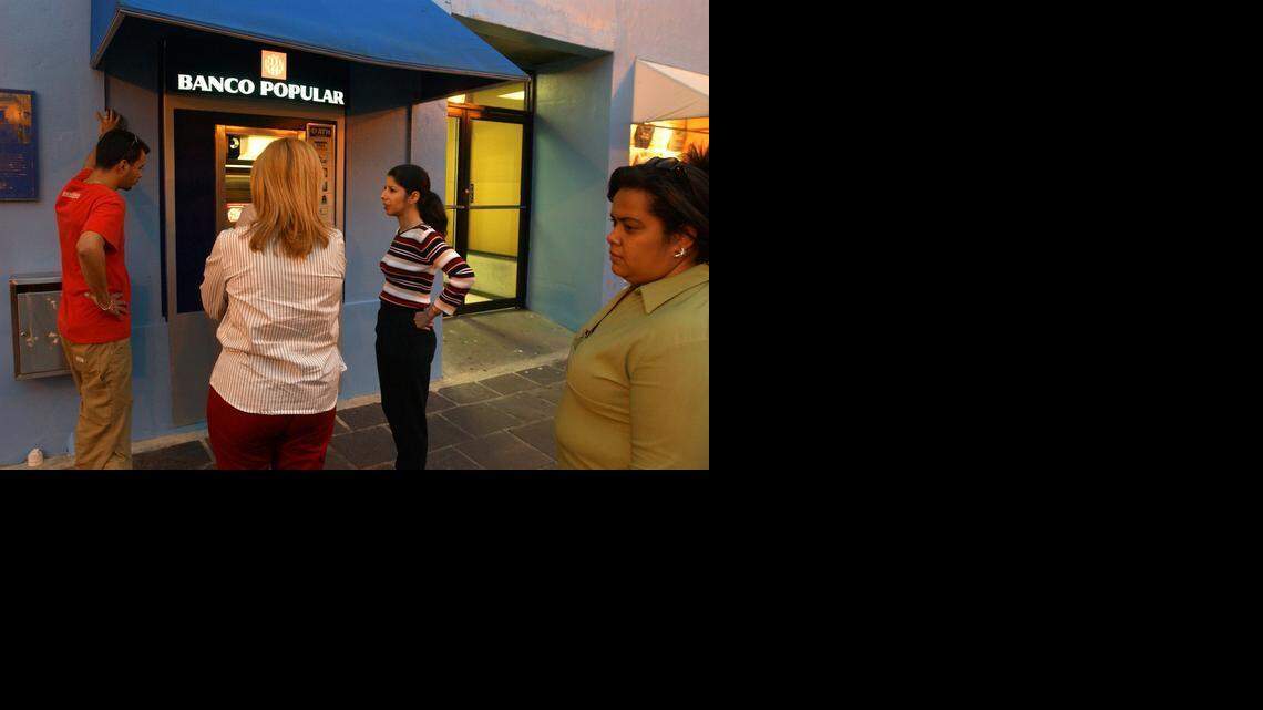 
People stand in line for a Banco Popular teller machine in San Juan, Puerto Rico.
