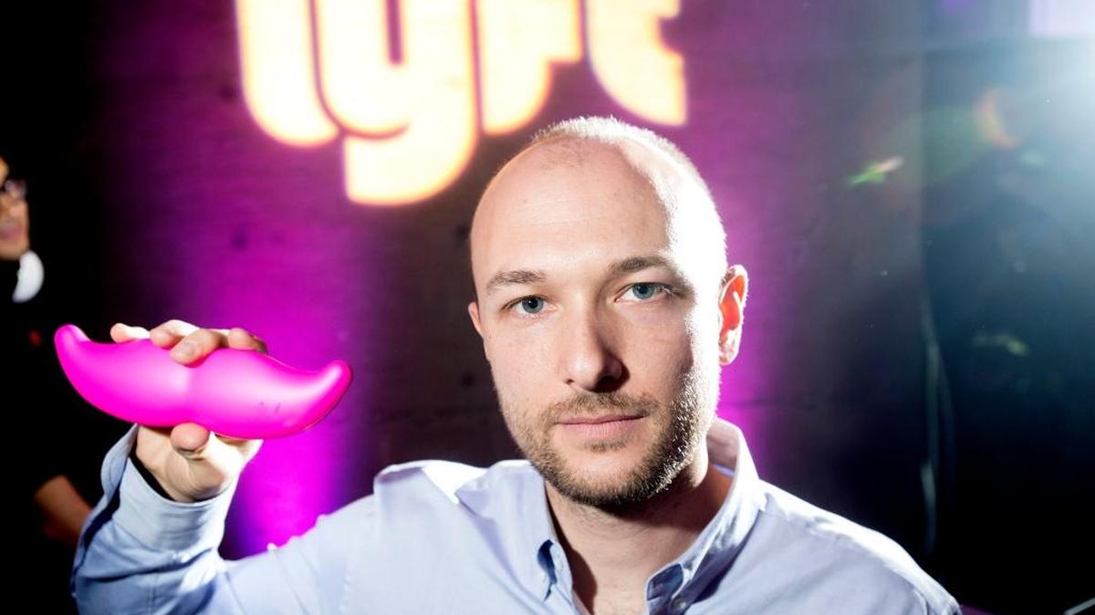 In this Jan. 26, 2015, file photo, Logan Green, co-founder and chief executive officer of Lyft, displays his company’s “glowstache” during a launch event in San Francisco. On Monday, Jan. 4, 2016, General Motors Co. announced it is investing $500 million in ride-sharing company Lyft Inc. GM gets a seat on Lyft’s board as part of the partnership, which could speed the development of on-demand, self-driving cars.