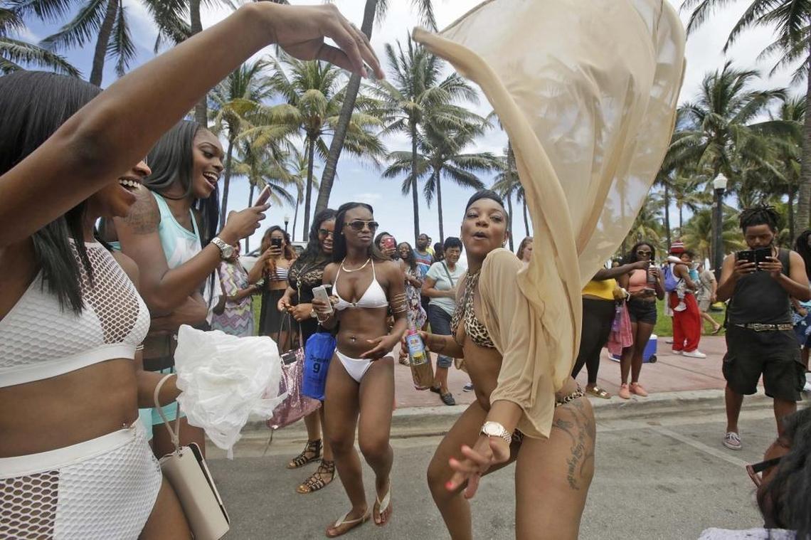 Mona Smith,center, from Michigan, dances on Ocean Drive during Memorial Day in Miami Beach, on Monday May 30, 2016.