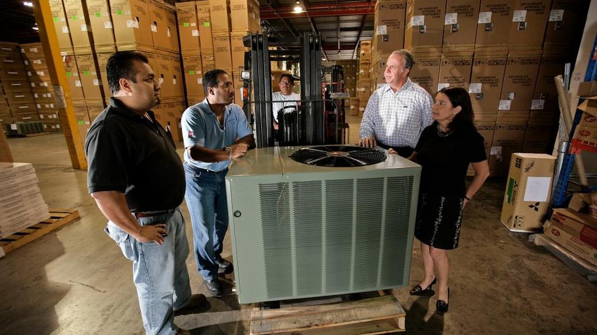 In this file photo from 2009, warehouse manager Carlos Borja, left, operations manager Mario Toledo, Barry Logan, senior VP of Watsco, Inc., and CFO Ana M. Menendez, right, discuss business at Gemaire, one of the air conditioning supply companies Watsco owns.