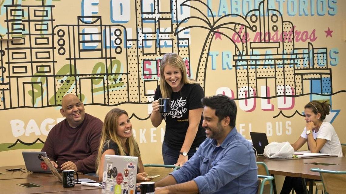 Anna Prisse (standing), WeWork’s Miami community manager, chats with Alberto Marin of Facilcloud, Amy Dannheim of purdyave.com and Gerardo Sandoval of Facilcloud in an open area at the WeWork Lincoln Road space last year.