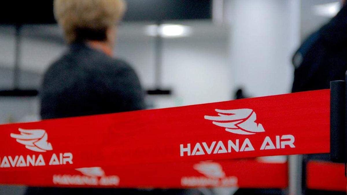 A woman waits in line with her luggage to check-in to a Havana Air charter flight to Cuba. 
