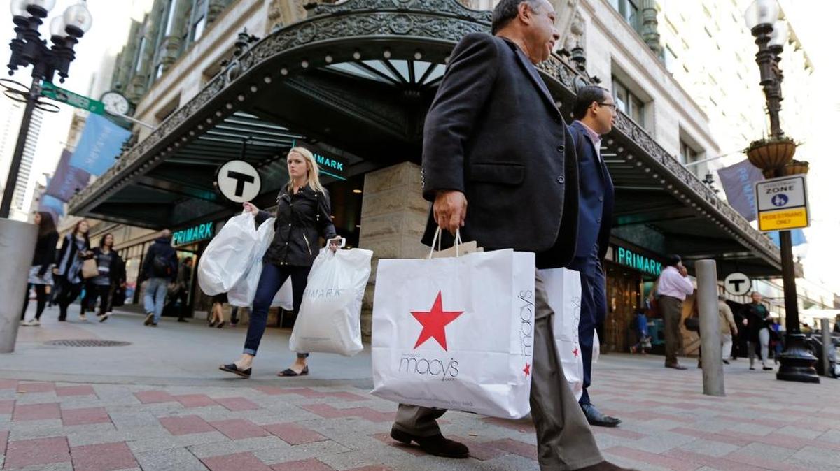 In this Wednesday, May 18, 2016, photo, shoppers carry their bags through the Downtown Crossing of Boston. The University of Michigan’s monthly index of consumer sentiment on Friday was at its highest level in a year.
