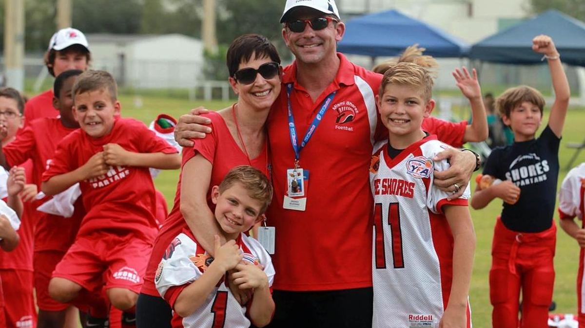 
The Bejerano family; wife, Karin Bejerano; and her husband, Andres Bejerano; poses for a photo with their son Trystan (1); left, and Bryson, (11), right; at one of their games Saturday, Aug. 22, 2105, in Kendall. Andres coaches his son's football team and helps with shuttling kids to activities. 
