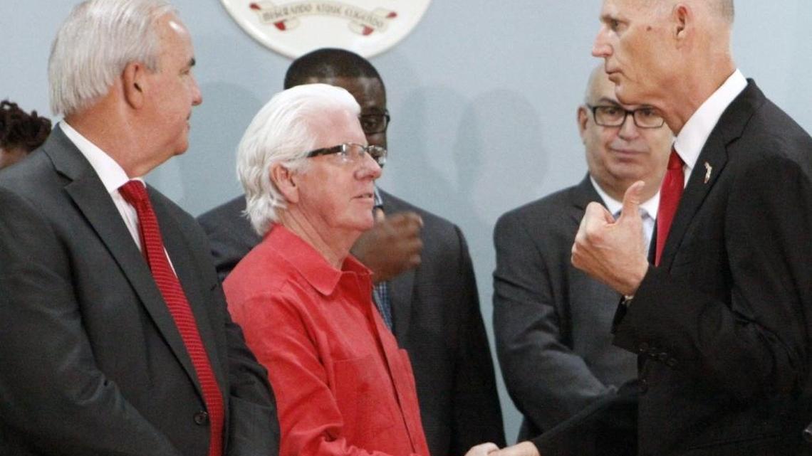 After announcing he lifted the zone of active Zika transmission in one square mile of Miami's Little River neighborhood, Gov. Rick Scott, right, shakes hands with William D. Talbert, III, president and CEO of the Greater Miami Convention & Visitors Bureau, center. At left is Miami-Dade County Mayor Carlos Giménez. The announcement was on Friday morning, Dec. 2, 2016 at St. Mary Cathedral School, 7485 NW Second Ave., Miami.