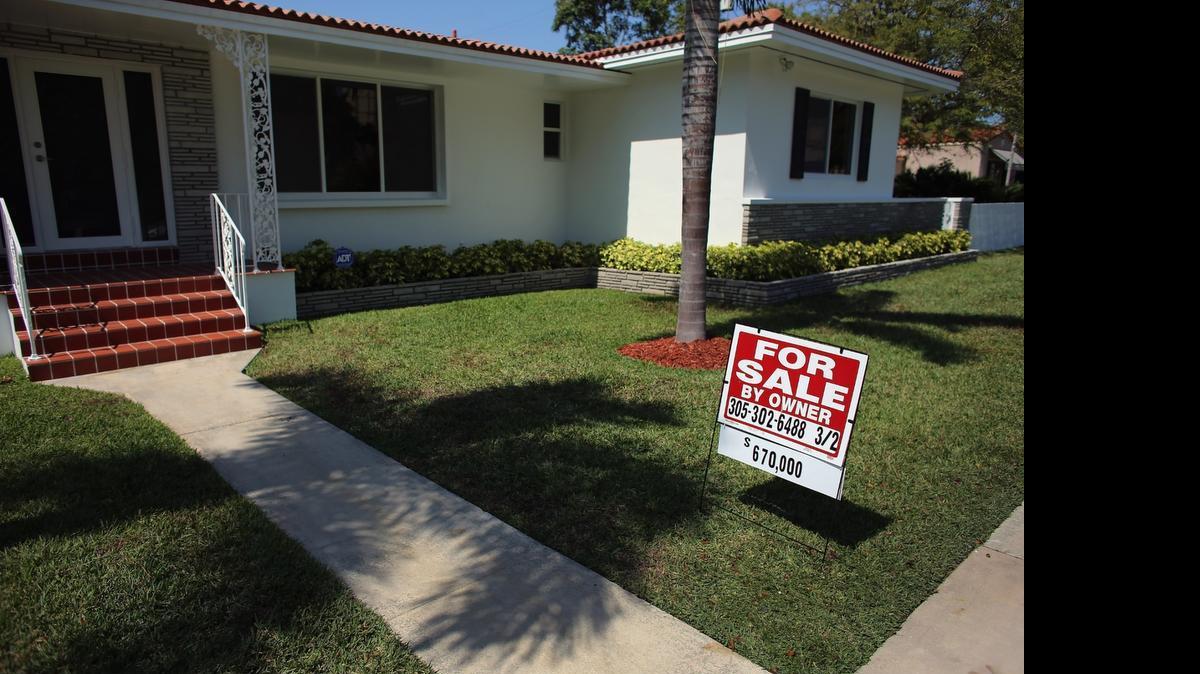 
A “for sale” sign stands in front of a home in Miami in 2013.
