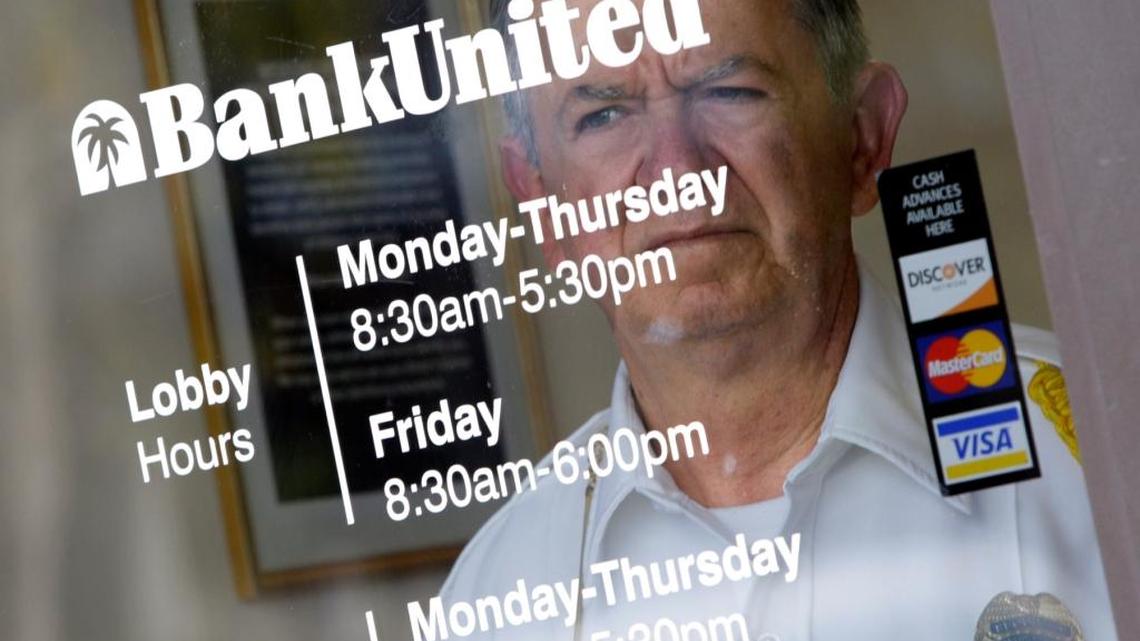 A security guard looks out the door of a BankUnited branch in South Miami in this Miami Herald file photo.