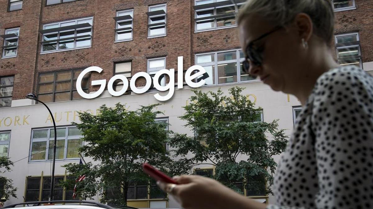 A woman looks at her smartphone as she walks past Google Building 8510 at 85 10th Ave in New York City. Shares of Google parent company Alphabet were down over 6 percent on June 3, following news reports that the U.S. Department of Justice is preparing to launch an anti-trust investigation aimed at Google and other big technology companies. Congress is not known for working fast, but only a week after the announcement, a House committee will hold its first public hearing.