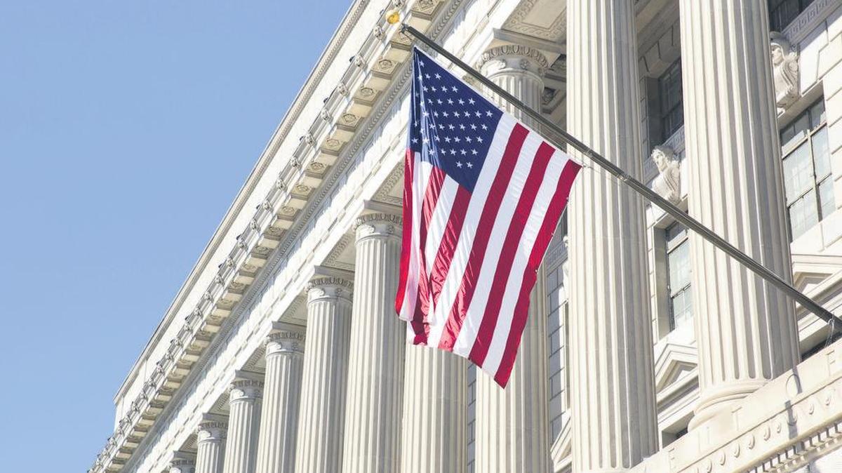 American flag flies at the U.S. Department of Commerce in Washington, D.C. As of the week ahead, the U.S. economy has been expanding for 10 years. It marks the longest economic expansion in American history.