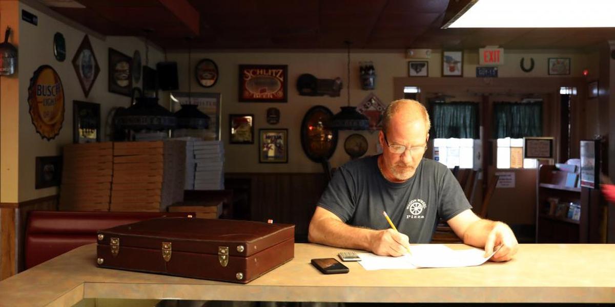 Keith Elwood, owner of Wagon Wheel Pizza in Palm Bay, fills out a worksheet for the Paycheck Protection Program, a federal small-business loan designed to help small-businesses stay open during in the wake of COVID-19, on April 6.