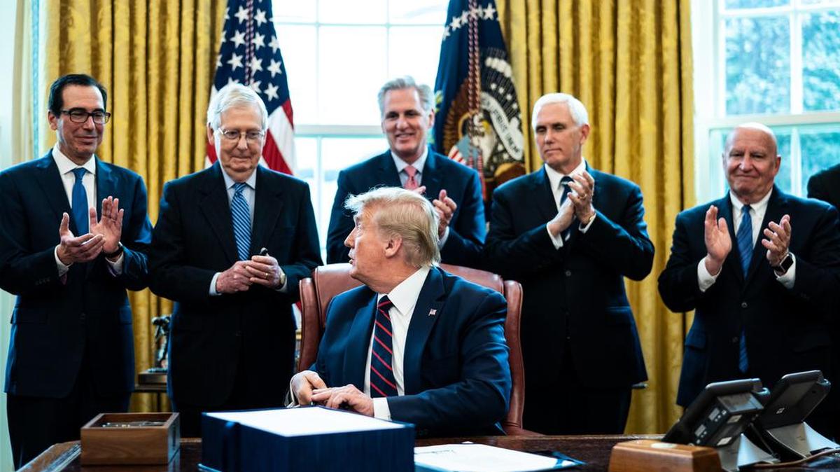 From left, Treasury Secretary Steven Mnuchin, Senate Majority Leader Mitch McConnell, R-Ky., House Minority Leader Kevin McCarthy, R-Calif., Vice President Mike Pence and Rep. Kevin Brady, R-Texas, applaud U.S. President Donald Trump during a bill signing ceremony for H.R. 748, the CARES Act in the Oval Office of the White House on March 27, 2020, in Washington, DC. Earlier on Friday, the U.S. House of Representatives approved the $2 trillion stimulus bill that lawmakers hope will battle the economic effects of the COVID-19 pandemic.