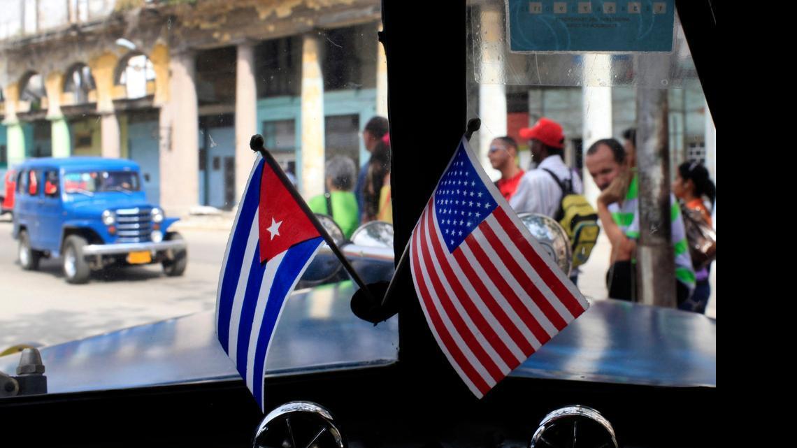 
In this March 22, 2013 file photo, miniature flags representing Cuba and the U.S. are displayed on the dash of an American classic car in Havana, Cuba. 
