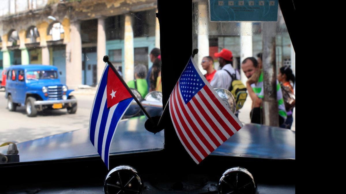 
In this March 22, 2013 file photo, miniature flags representing Cuba and the U.S. are displayed on the dash of an American classic car in Havana, Cuba. 
