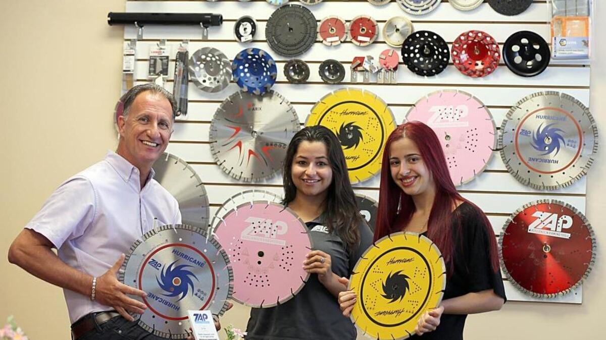 
Paulo Lins, owner-founder of Zap Diamond Tools, poses with members of his team Jessika Messina, center, and Fernanda Almeida. His company sells diamond tipped blades that are used to cut stoneware and concrete for construction projects in Pompano Beach.

