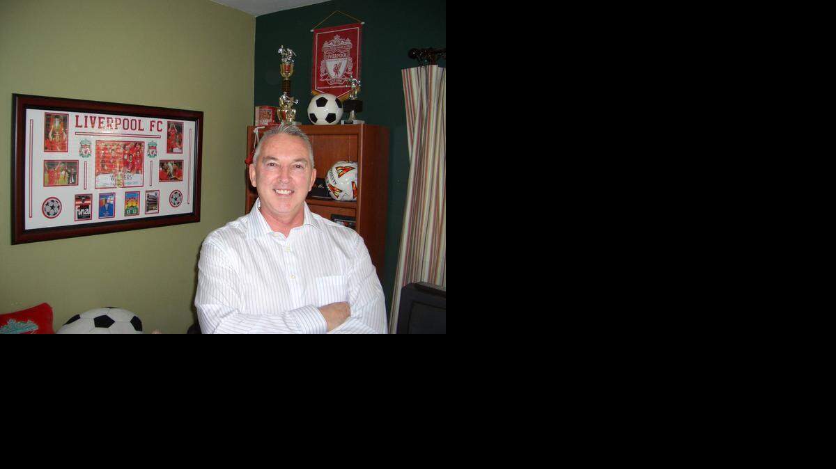 AT OPENWIDE: Roy Yates, VP of sales and marketing for Openwide International USA, at his Lighthouse Point office. Yates, a Briton and fan of the Liverpool Soccer Club, oversees Openwide’s tourism, leisure and entertainment business in the U.S.