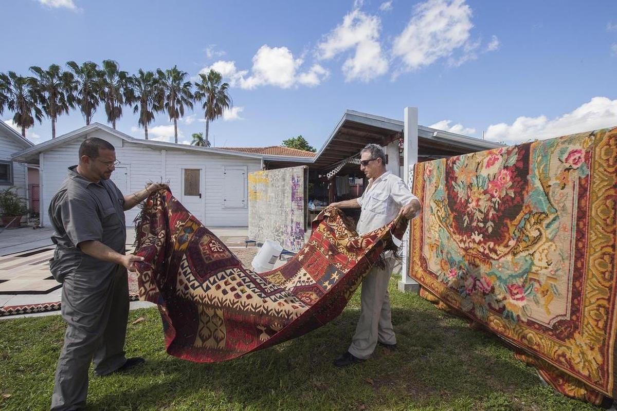 Paul Kondralian, left, and Terry Kondralian work on carpets in South Miami on Nov 8.