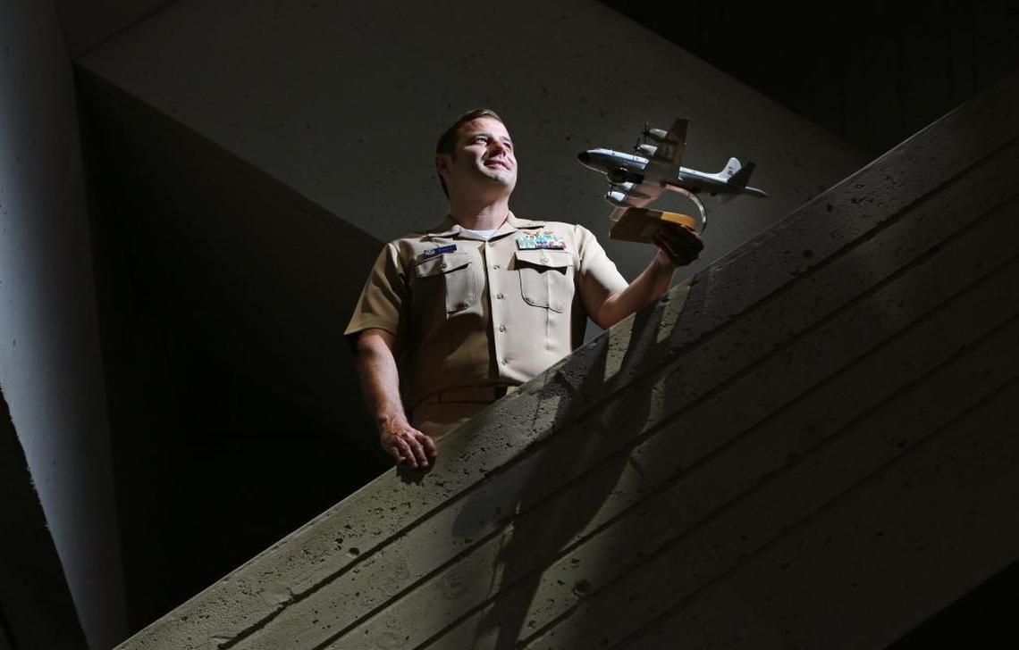 Hurricane Hunter Commander Justin Kibbey pilots the P-3 airplane that flies into hurricanes. Kibbey is currently the director of the building at the the National Oceanographic and Atmospheric facility in Virginia Key. He holds a model of the P-3 that he flies.