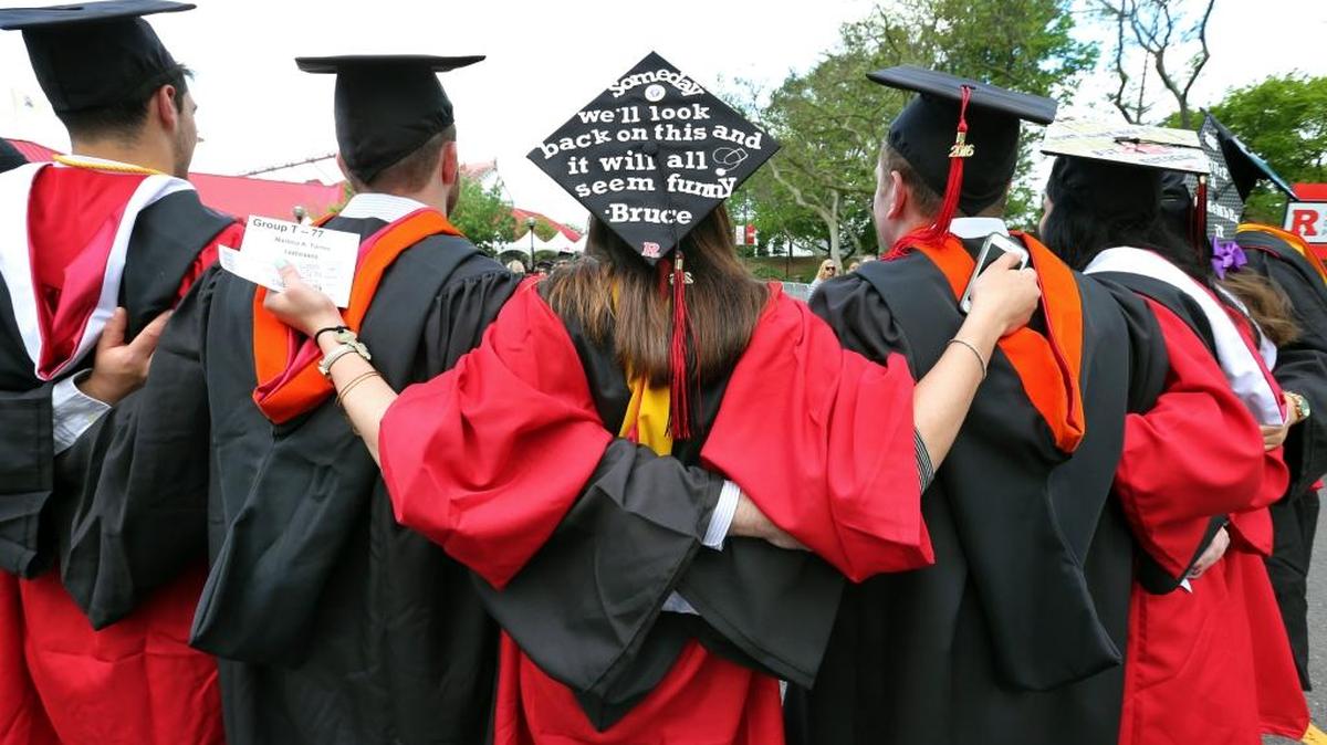 Students embrace as they arrive for the Rutgers graduation ceremonies in Piscataway, N.J., in 2016. More Americans are getting buried by student debt, causing delays in home ownership, limiting how much people can save and leaving taxpayers at risk as many loans go unpaid.