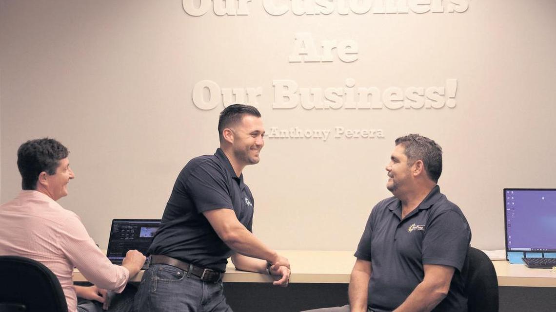 Anthony Perera, president of Air Pros, center, a company that installs and repairs residential and commercial air conditioning in Miami-Dade, Broward and Palm Beach counties, catches up with Jason Stevens, left, employee, and Doug Perera, father, right, in the Davie, Florida, office on Feb. 13.