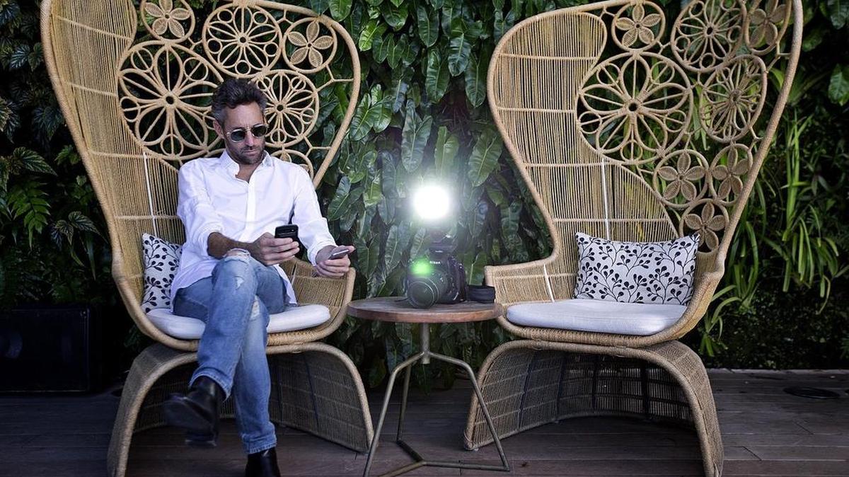 Miami photographer and World Red Eye photo company CEO Seth Browarnik works his mobile phones from Juvia Restaurant on Miami Beach.