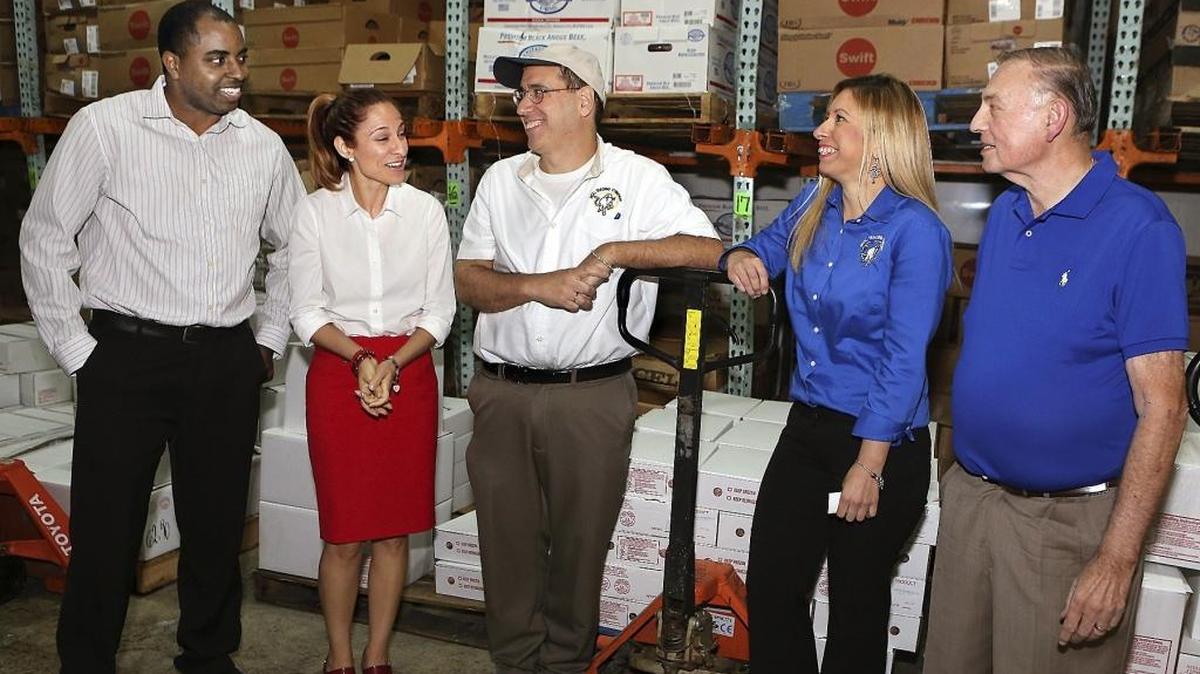 Nital Trading Company owner and President George Hernandez, center, and his daughter Vanessa Scaglia, right center, who handles sales and assists Hernandez, share a light moment with SCORE mentors Reginald Andre, left, Elizabeth Manso, and Kenneth Fordik in a holding cooler at the Medley business on Friday April 22, 2016. Nital Trading Company, a full-line meat distributor, is at 7277 NW 78th Terrace.