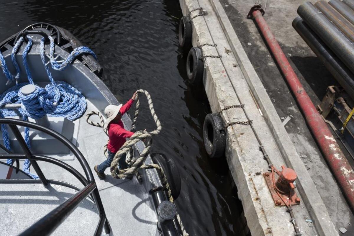 Sailor Rafael Benavides ties a tugboat to the dock as a trip concludes.