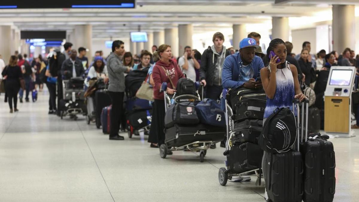 Passengers line up at Miami International Airport in January after flight delays.