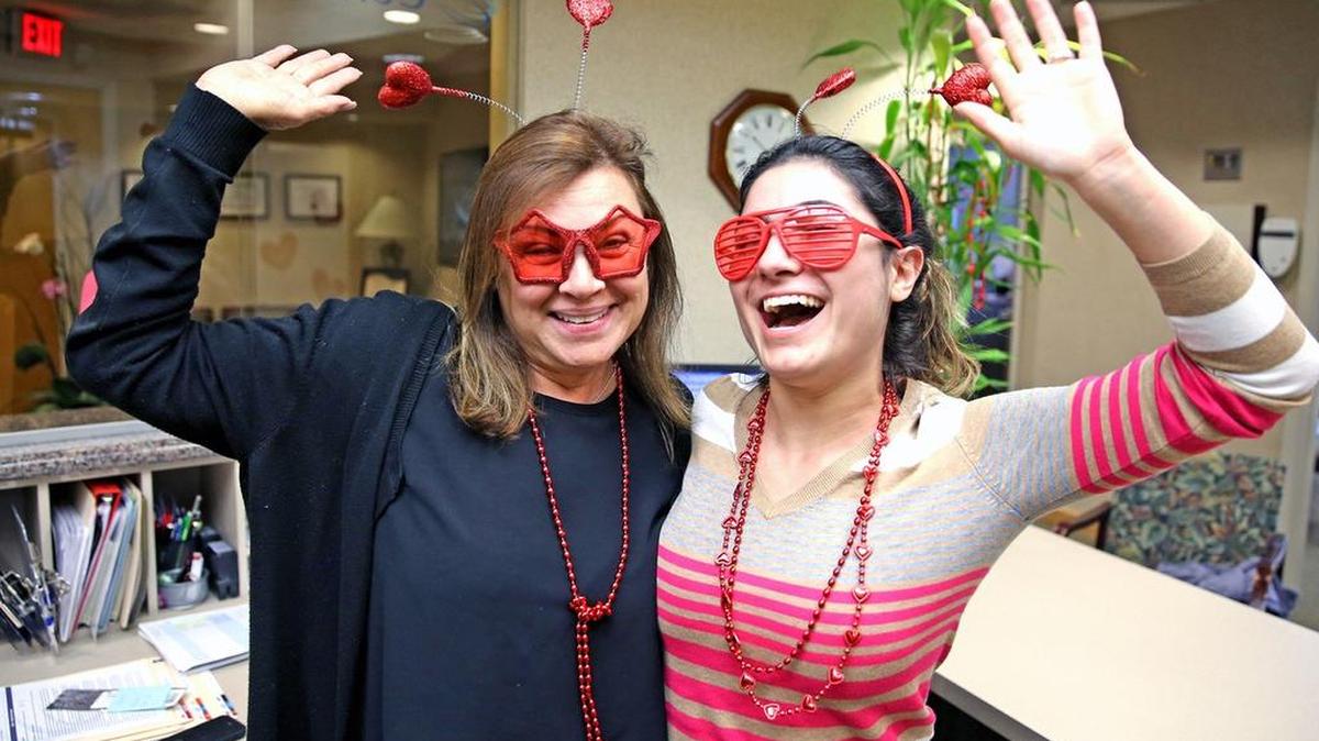 Carmen Quintana and Adriana Rodriguez wear Valentine’s Day costume attire at the Center for Dental Implants in Aventura.