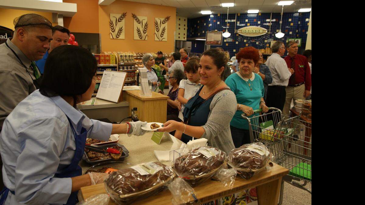 
Nicole Erdmann holds Arianna Ruz 3, sampling french toast at the newly remodeled Publix grand re-opening, at 9420 SW 56th Street in Miami on April 23.
