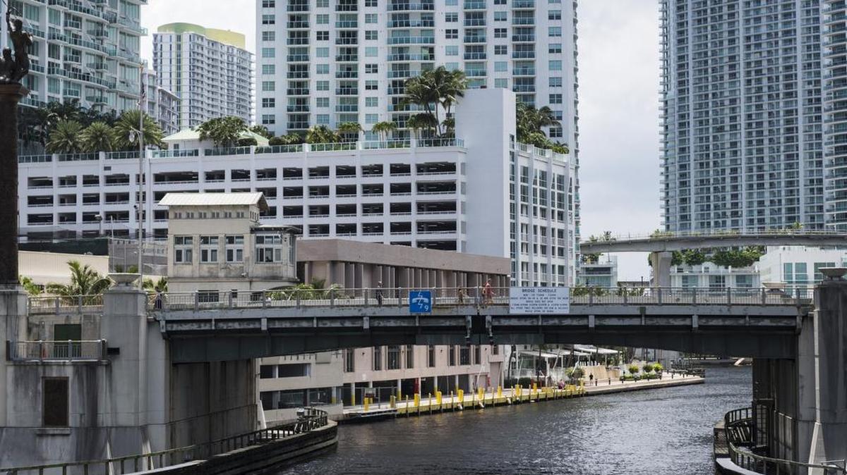 Pedestrians cross the Brickell Avenue drawbridge on June 29 — despite the crossing gates being down and the drawbridge operator, through speakers, asking them to stop.