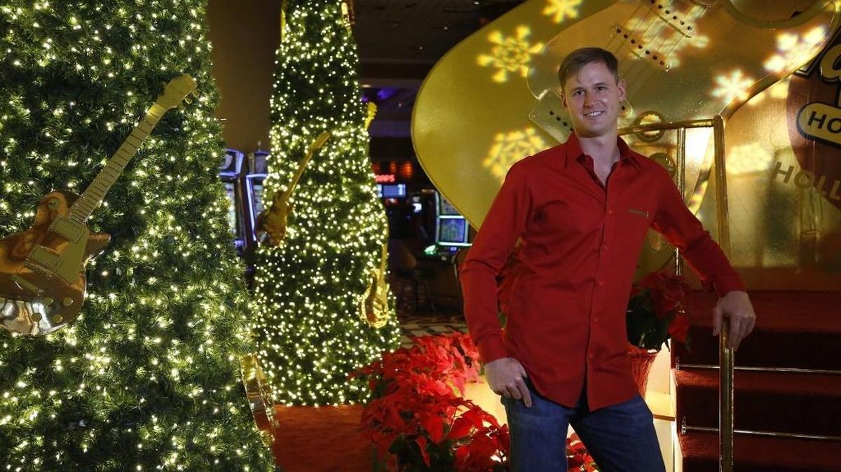 Kurt Stange owns Miami Christmas Lights, a company that puts together large holiday displays. He poses at the installation his company worked on in the lobby of the Seminole Hard Rock Hotel & Casino in Hollywood.