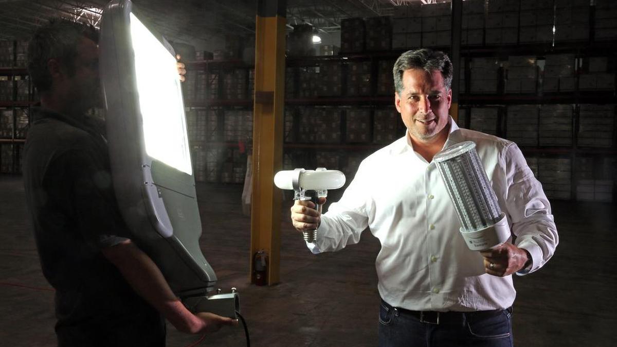 In the company’s Fort Lauderdale warehouse, CEO Daniel Gold holds some of the light fixtures installed by Future Energy Solutions.