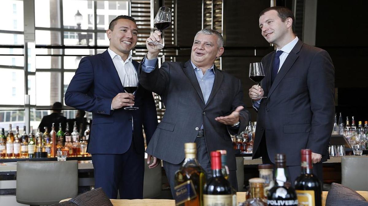 
Alfredo Picardi, food and beverage director at JW Marriott, center, stands with his mentees, Jonathan Galindo, left, and Miguel de Arregui, right, inside the Bistro Moderne restaurant/bar at the JW Marriott Marquis Miami. Photo taken July 22, 2015. 
