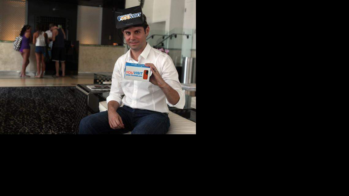 
YouVisit CEO Abi Mandelbaum poses in the lobby of the Dream Hotel in Miami Beach with his virtual reality headset and cellphone that can to used to view YouVisit tours. YouVisit, which was started as an online college tour company, is expanding into many industries including hospitality and travel. 
