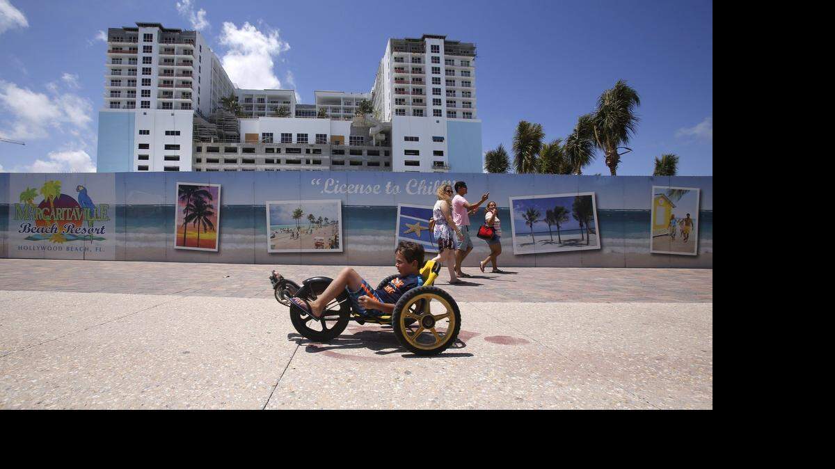
Margaritaville Hollywood Beach Resort is under construction as tourist and locals alike pass by the development's decorative wall on Monday, April 13, 2015 on Hollywood Beach.
