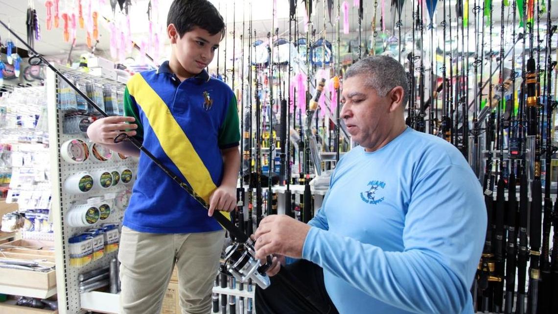 Carlos Alberto Martinez, 11 years old, with Elias Rodriguez, co-owner of Miami Fishing Supply.