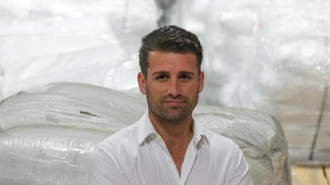 Luis Lopez, president and chief executive officer of DGD Transportation, stands in front of a row of pallets loaded with chia seeds in his warehouse in Doral.